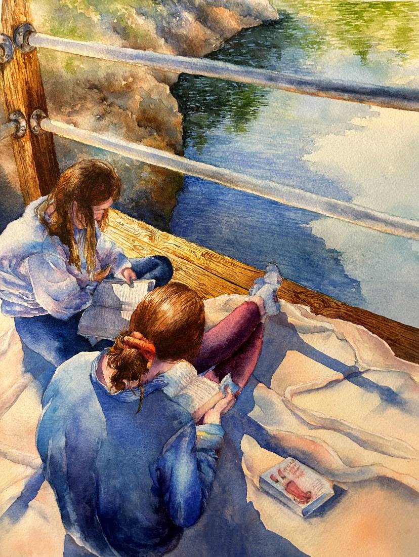 Two girls sit on a pier reading books.