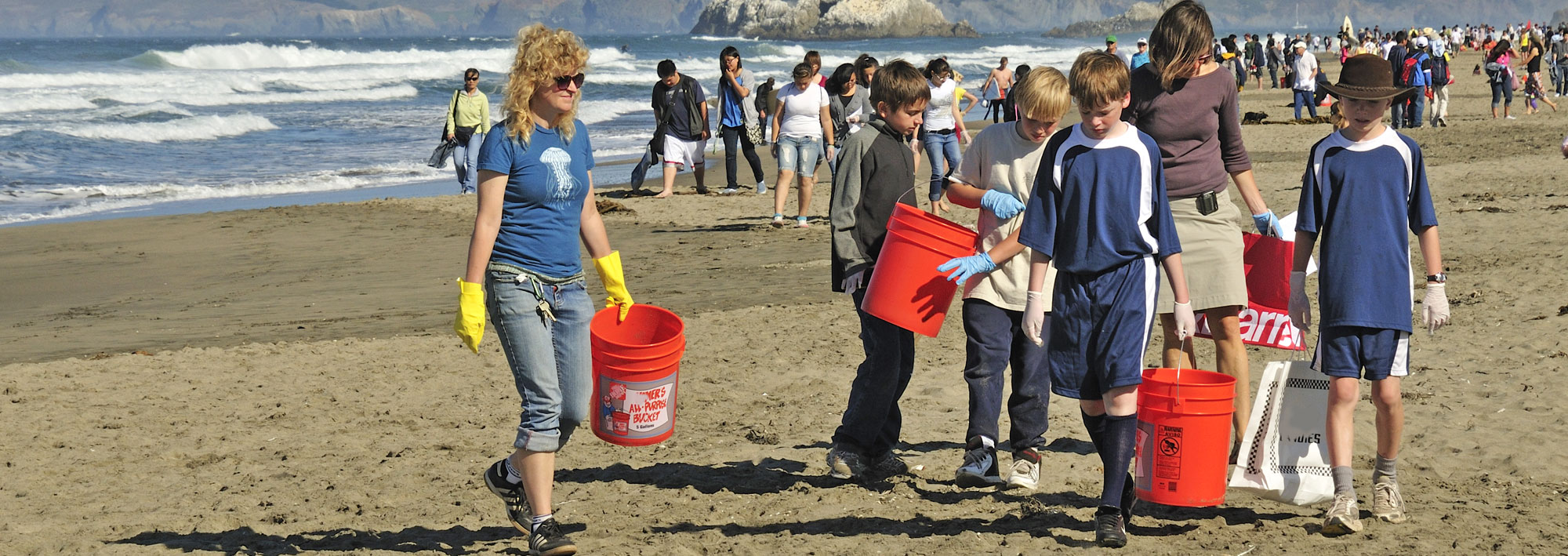People at a beach cleanup facing the ocean