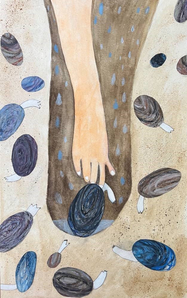 A hand reaches down into a hole to grab a clam. Other clams are under the sand.