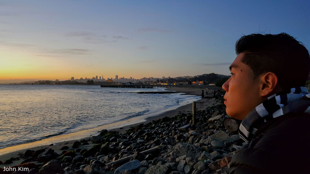 Photo of man in profile with San Francisco and bay in background, by John Kim