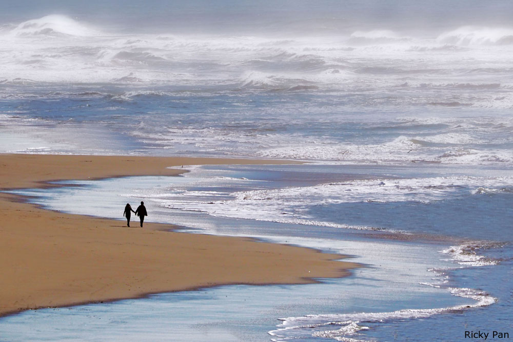Photo of two people walking on Ocean Beach in San Francisco, by Ricky Pan