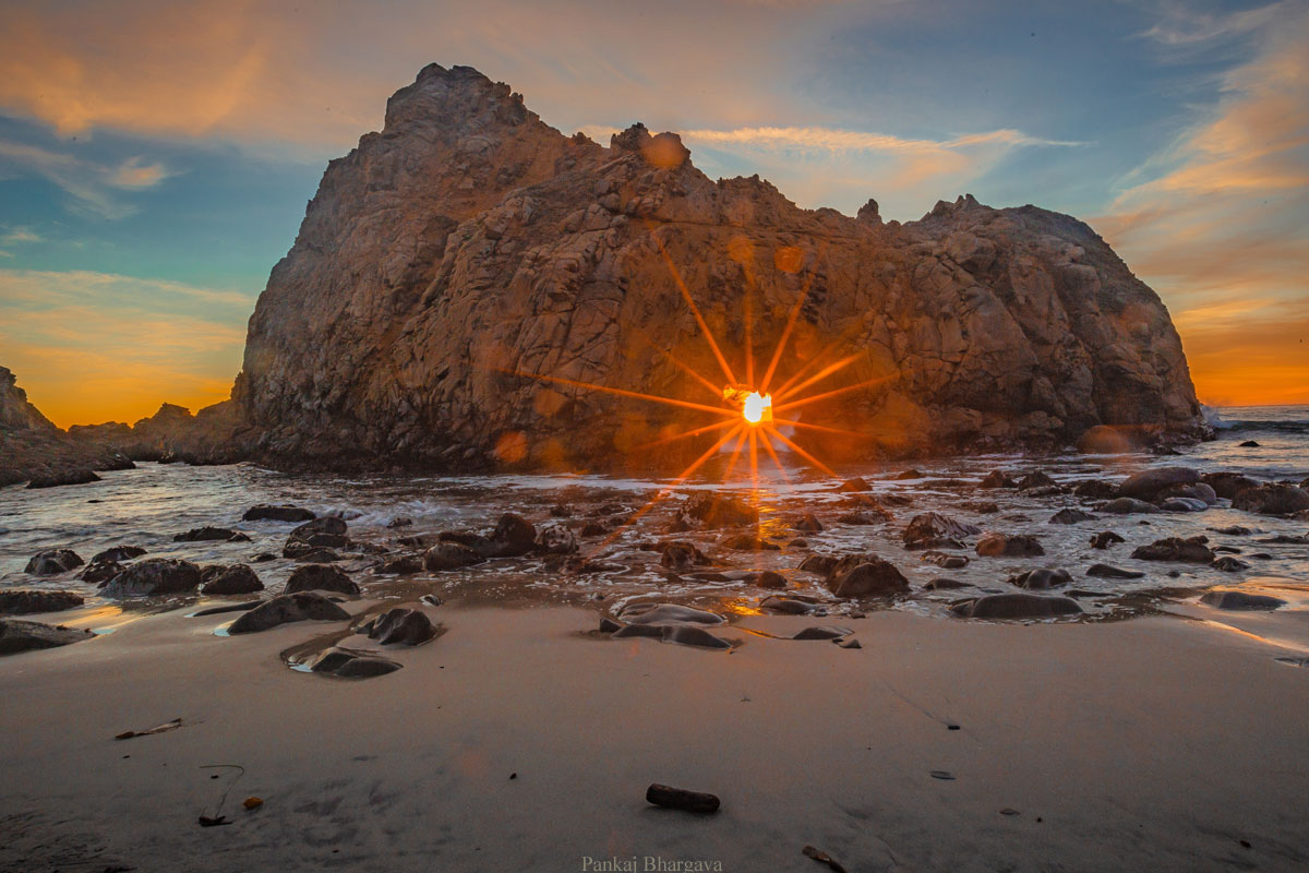 Photo of rock arch at Pfeiffer Beach with sun setting in the arch, by Pankaj Bhargava