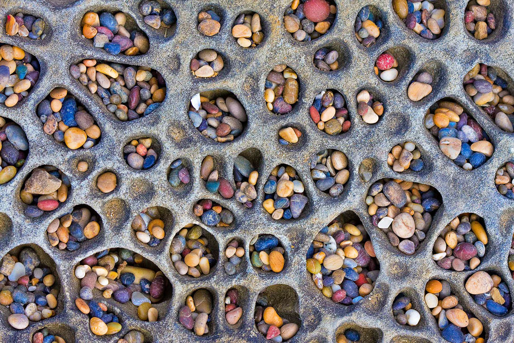 Erosion hollows out cups in the face of the larger rocks at Bean Hollow State Beach.  These pockets in the larger rocks are filled with surf polished pebbles.