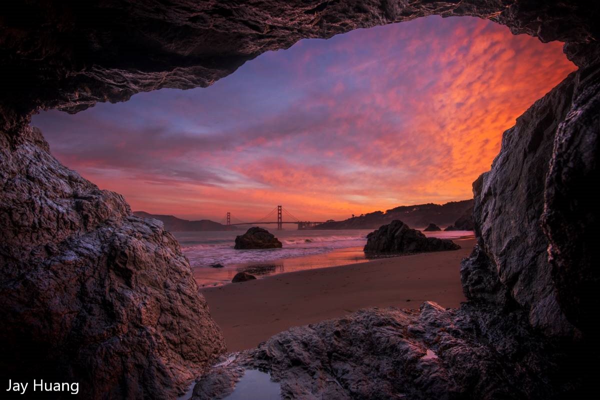 sunrise and Golden Gate Bridge framed looking out from a cave