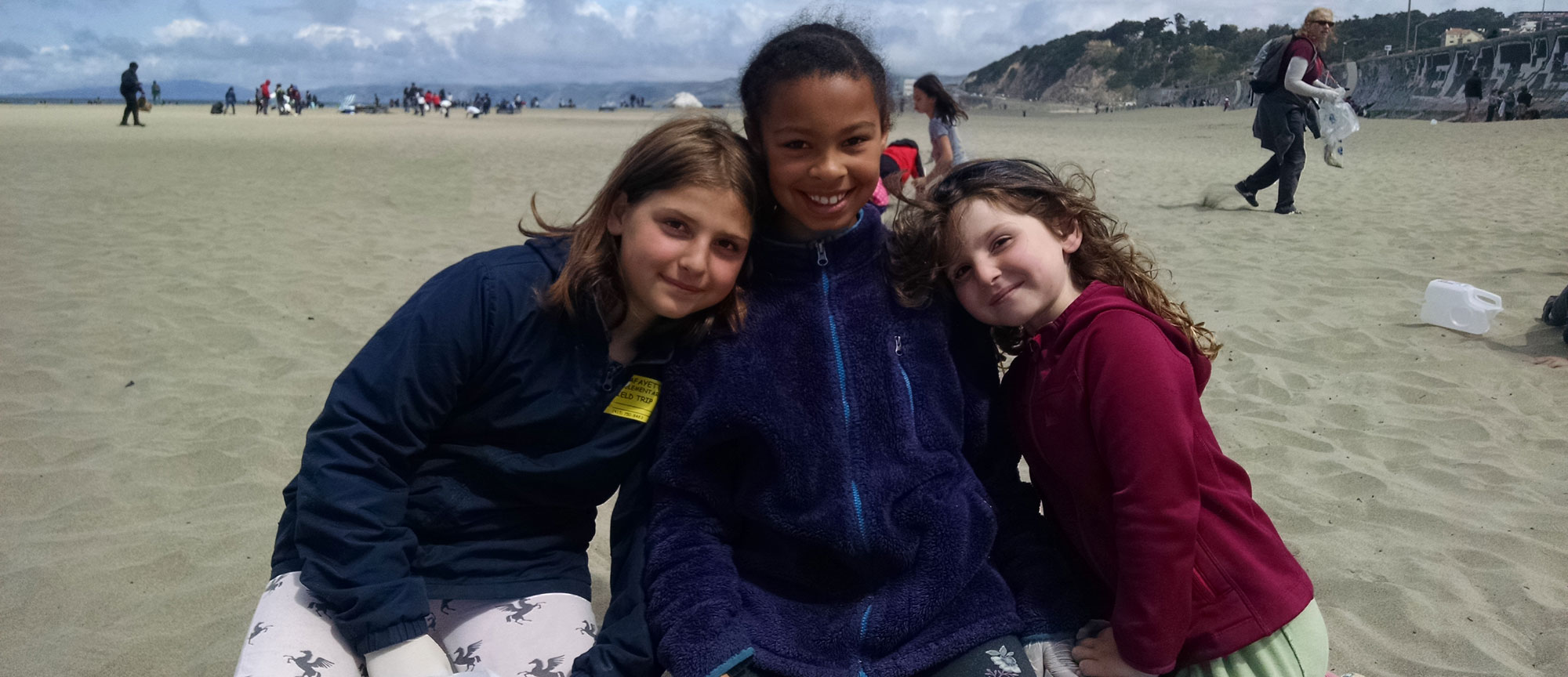 Smiling girls at a beach cleanup