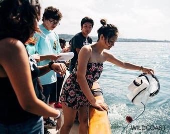 Students on a boat collecting water samples for WILDCOAST